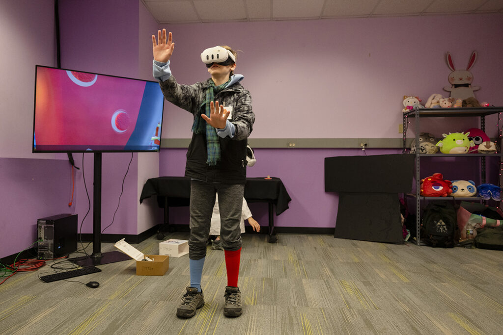 A Festival guest wearing a VR headset makes their way through a student-created immersive experience
