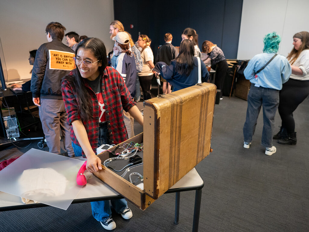 Encore team member Jasmin Ali-Diaz adjusts the tech on one of the luggage stations