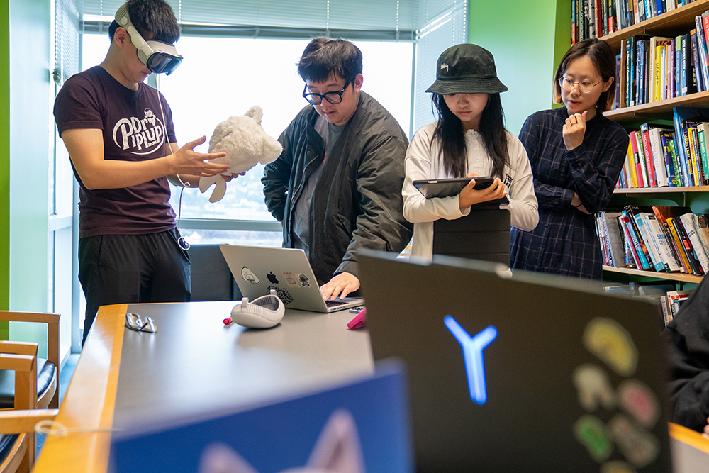 Brian He troubleshoots the Apple Vision Pro in between playtesting sessions with help from Jerry Zheng, Paige Li, and Sophie Huang 